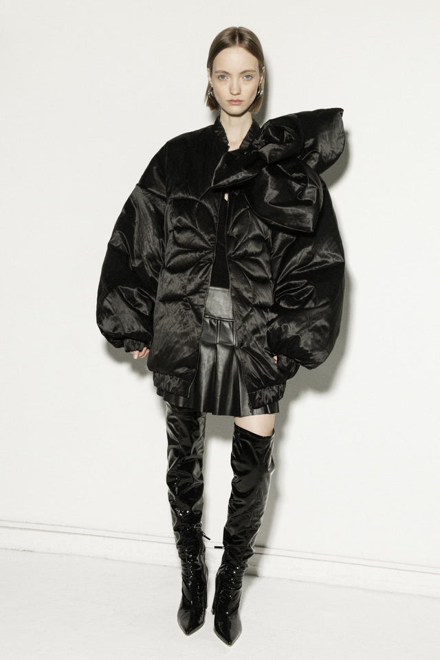 Model in long insulated bomber jacket with a 3d flower decor