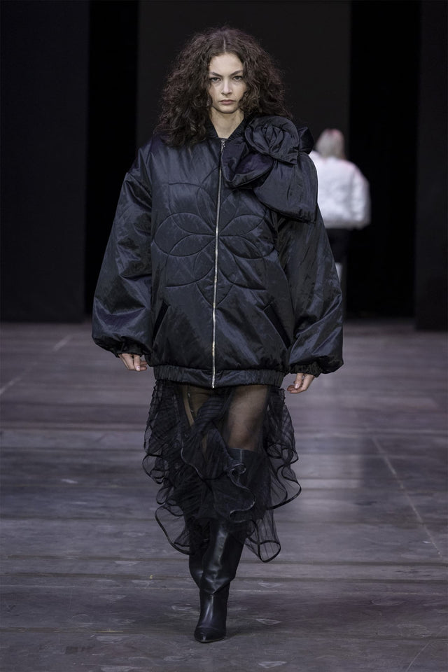 Model in long insulated bomber jacket with a 3d flower decor