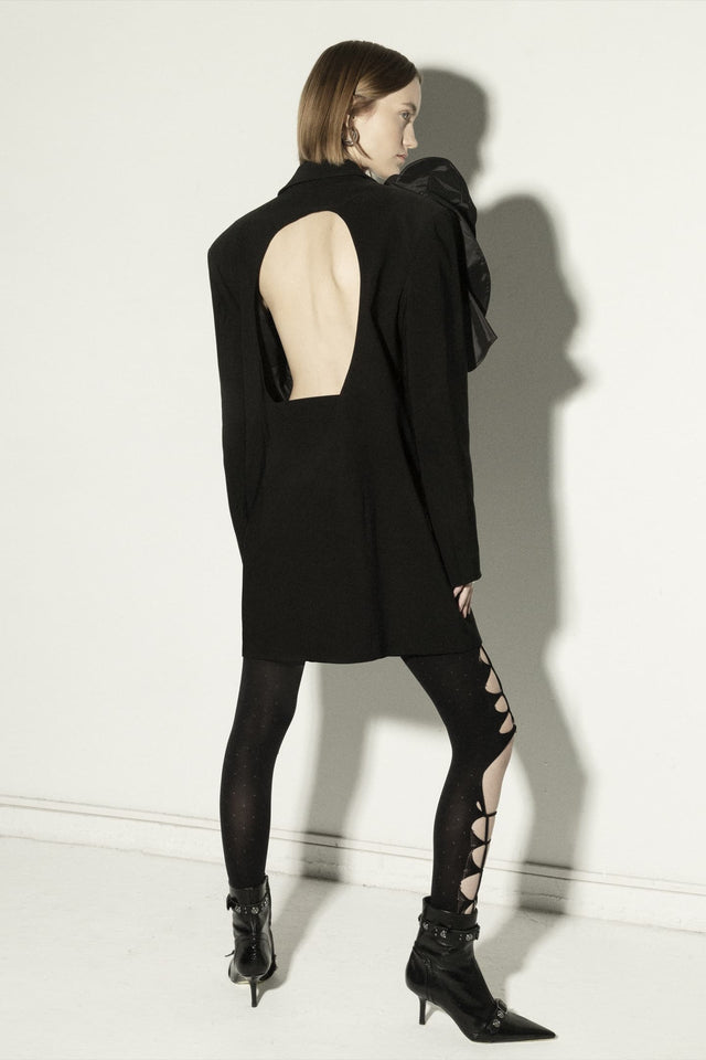 Model in long jacket with open back and 3d flower decor
