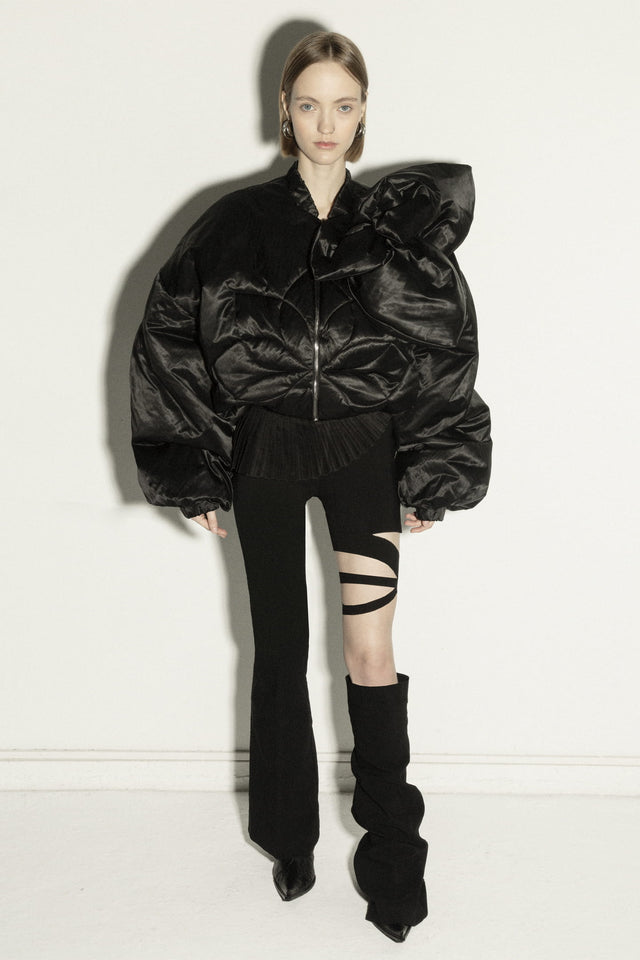Model in short insulated bomber jacket with a 3d flower