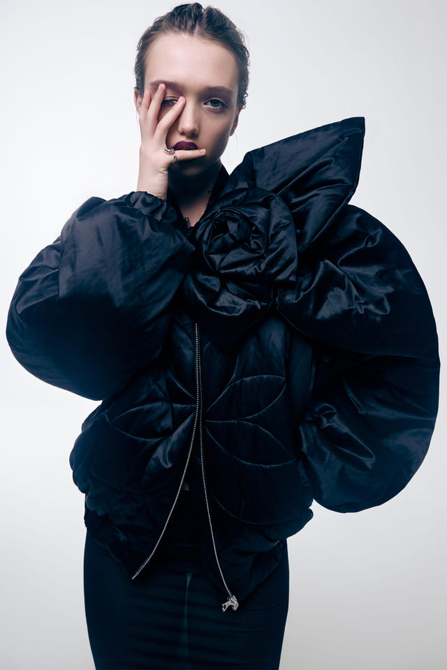 Model in short insulated bomber jacket with a 3d flower