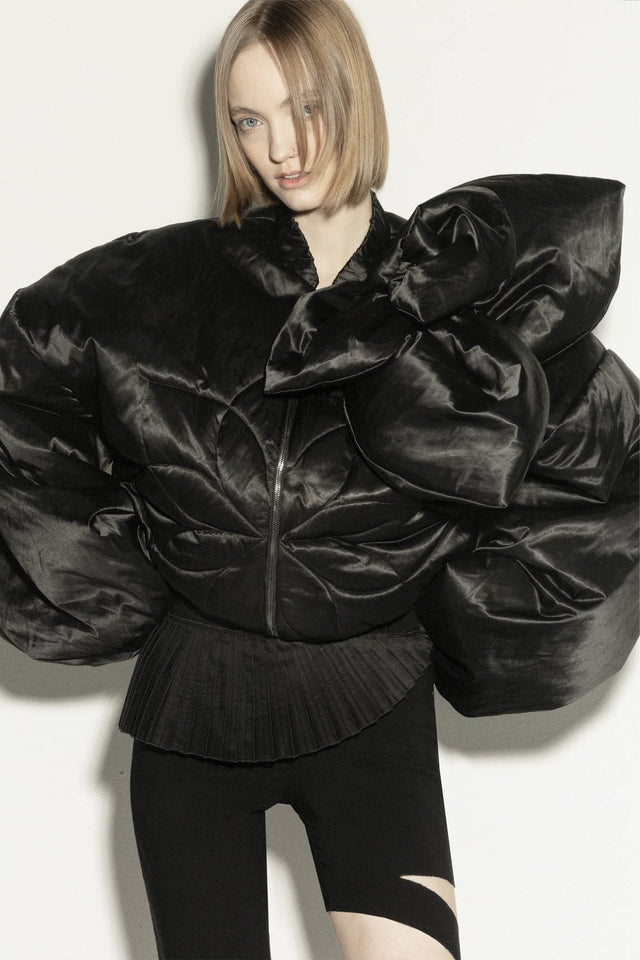Model in short insulated bomber jacket with a 3d flower