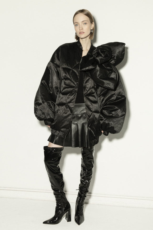Model in long insulated bomber jacket with a 3d flower decor