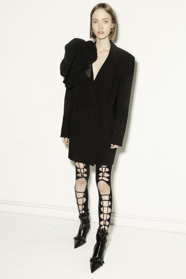 Model in long jacket with open back and 3d flower decor